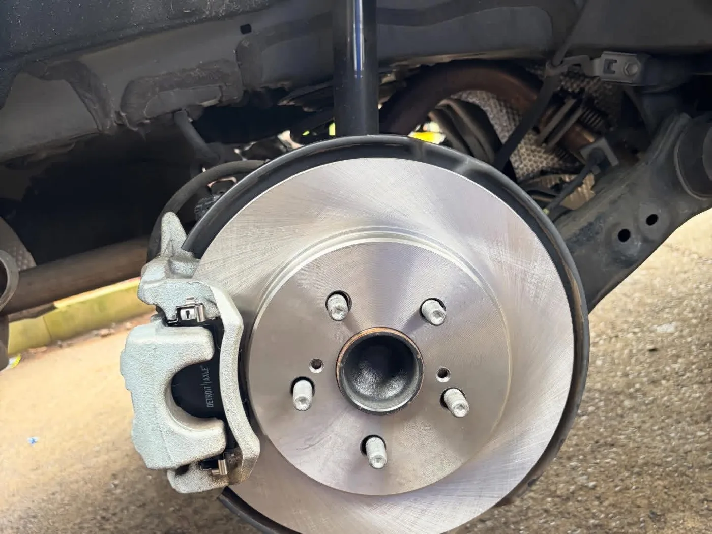 New brake rotor and caliper installed on a car